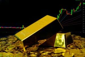 Gold bullion on pile gold coins at trading chart background